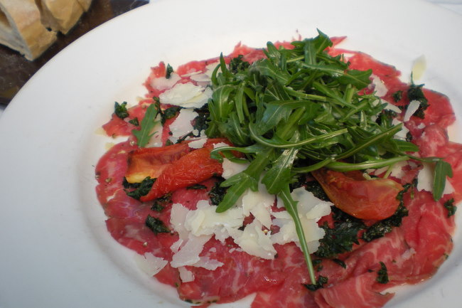 Wagyu Carpaccio with wild rocket, semi-dried tomato, truffle oil and crisp parsley